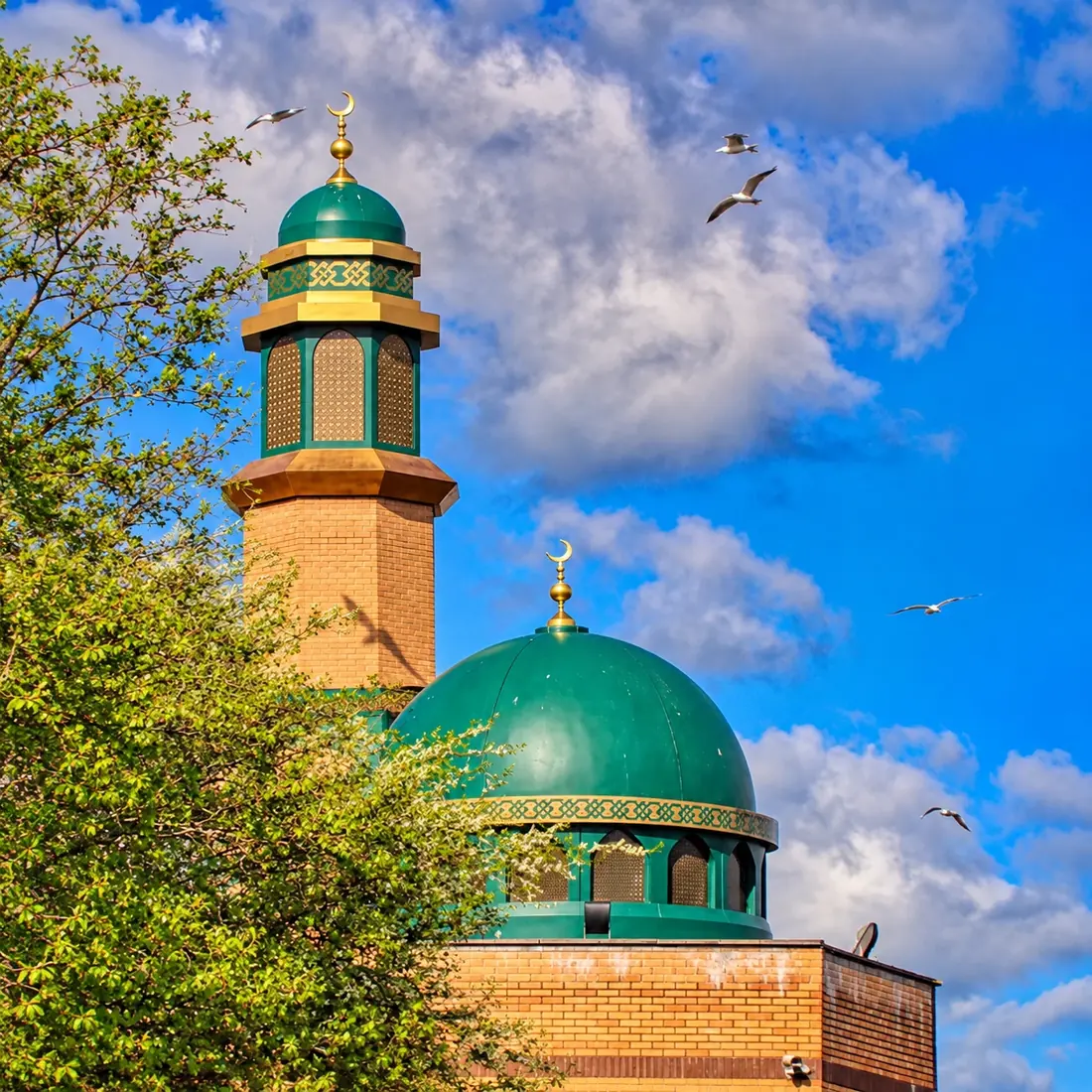 En moské med grøn kuppel og minaret